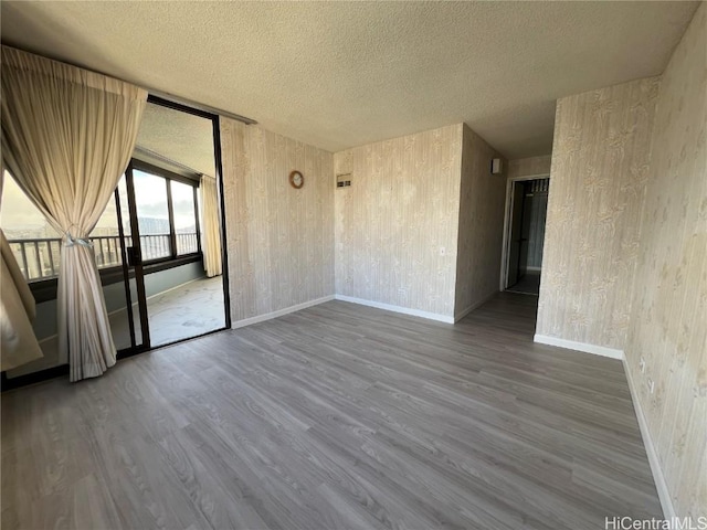 spare room featuring hardwood / wood-style flooring and a textured ceiling