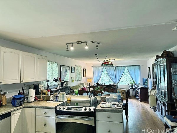 kitchen with appliances with stainless steel finishes, wood-type flooring, and white cabinets