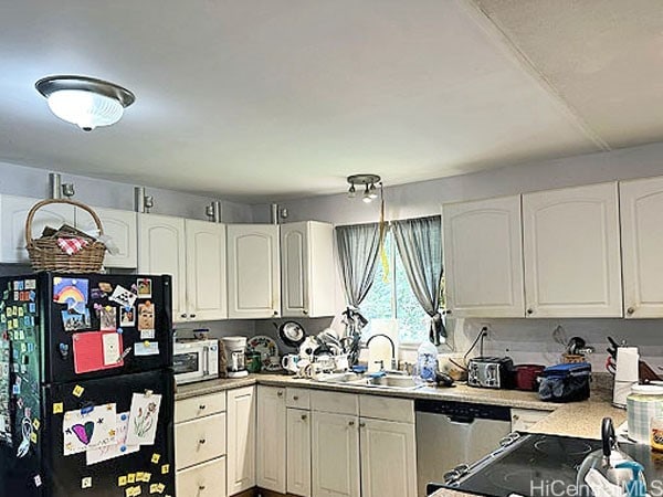 kitchen with appliances with stainless steel finishes, sink, and white cabinets