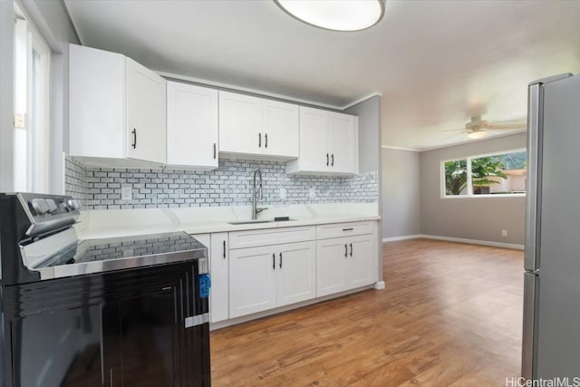 kitchen featuring ceiling fan, sink, decorative backsplash, white cabinets, and appliances with stainless steel finishes