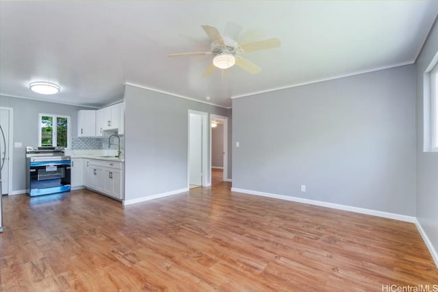 unfurnished living room featuring ceiling fan, ornamental molding, sink, and light hardwood / wood-style flooring