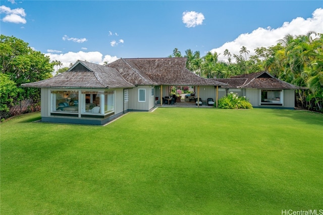 rear view of property with a yard and a patio