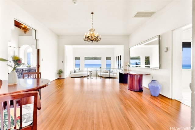 corridor featuring ornamental molding, a chandelier, wood-type flooring, and a water view