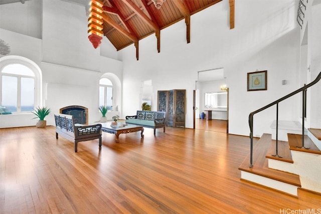 living room with a healthy amount of sunlight, wood-type flooring, high vaulted ceiling, and wooden ceiling