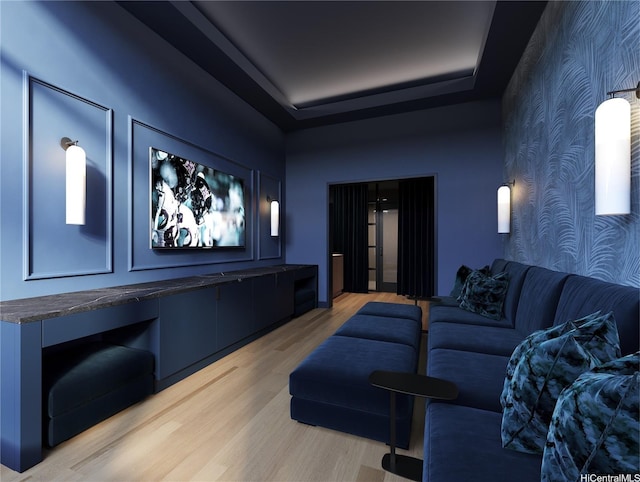 cinema room featuring wallpapered walls, an accent wall, and light wood-style floors