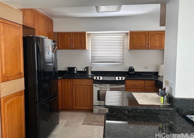 kitchen with dark stone counters, stainless steel range with electric cooktop, and black refrigerator