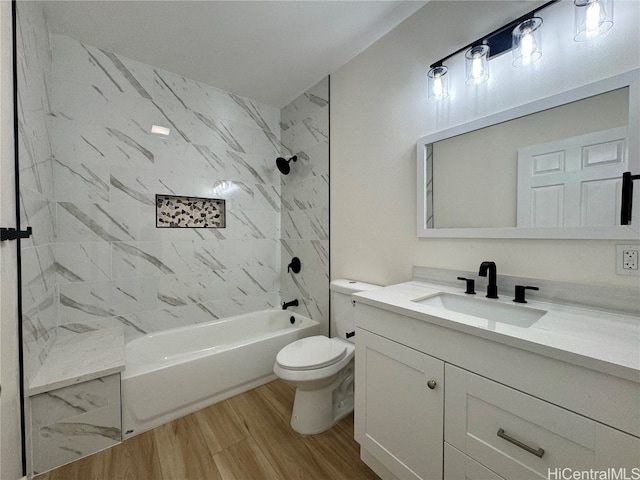 full bathroom featuring toilet, tiled shower / bath, hardwood / wood-style flooring, and vanity