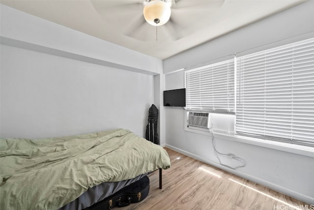 bedroom with ceiling fan, light hardwood / wood-style flooring, and cooling unit