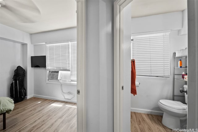 bathroom featuring wood-type flooring, toilet, and cooling unit