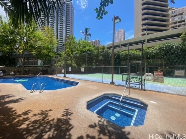 view of pool with a patio and a hot tub