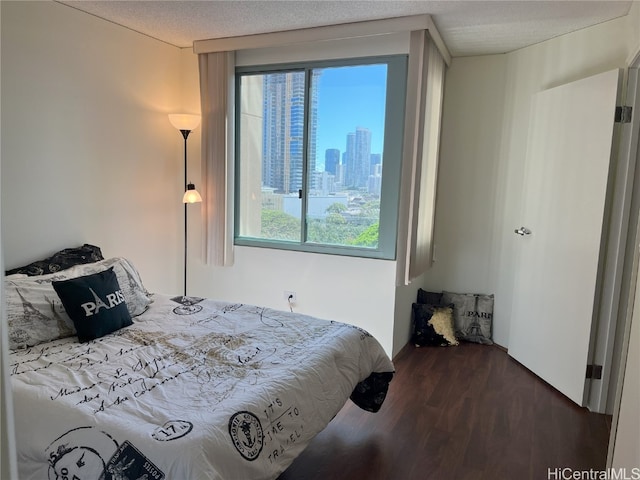 bedroom with dark wood-type flooring and a textured ceiling