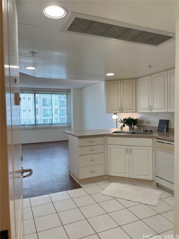 kitchen featuring white cabinets, white dishwasher, and light tile patterned floors