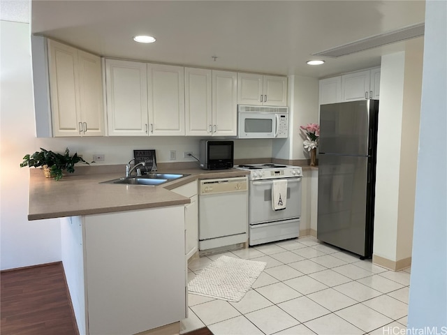 kitchen featuring kitchen peninsula, white cabinets, sink, and white appliances