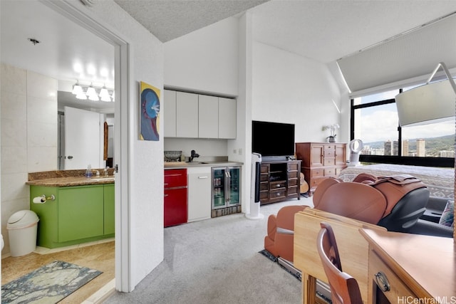 carpeted living room featuring wine cooler, sink, vaulted ceiling, tile walls, and a textured ceiling