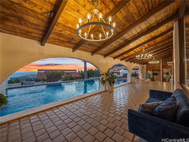 pool at dusk featuring a chandelier