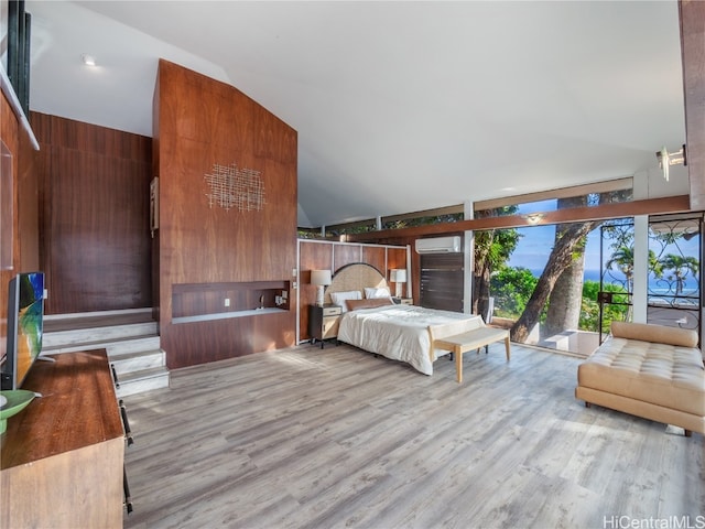 bedroom featuring light wood-type flooring, a wall mounted AC, lofted ceiling, and wood walls