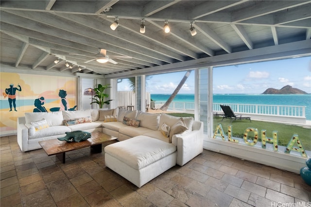 sunroom / solarium with a water view, ceiling fan, and rail lighting