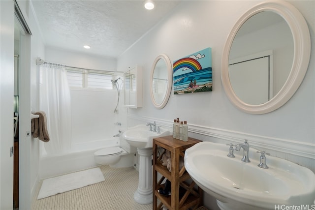 full bathroom with sink, a textured ceiling, toilet, shower / bath combo with shower curtain, and tile patterned floors