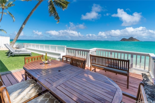 wooden terrace with a yard and a water view