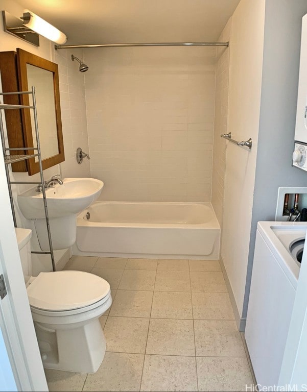 bathroom featuring toilet, tile patterned floors, and tiled shower / bath