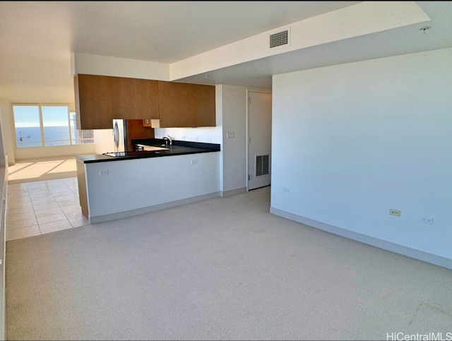 kitchen featuring sink, a water view, and light tile patterned floors