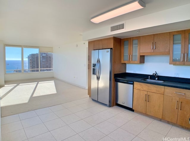 kitchen with appliances with stainless steel finishes, sink, and light tile patterned floors