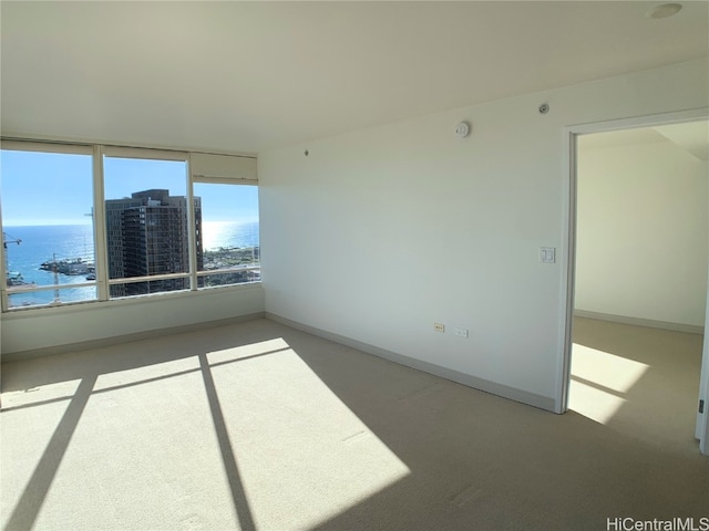 carpeted spare room with a water view