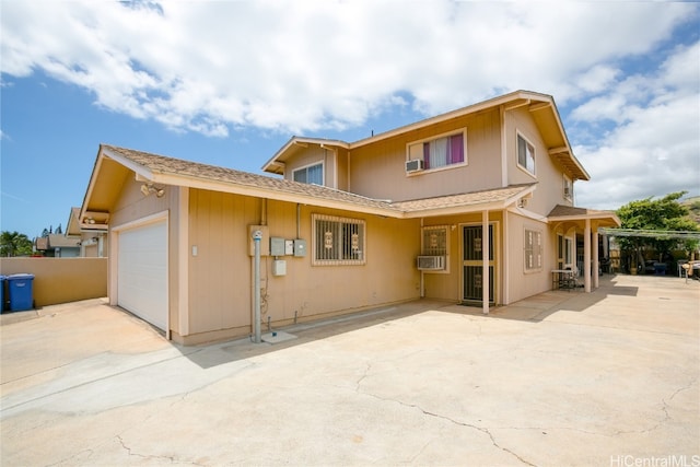 back of property with a garage and cooling unit