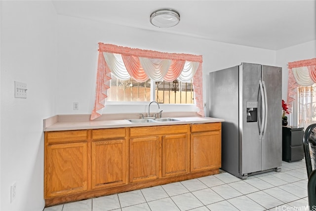 kitchen featuring stainless steel fridge, sink, and light tile patterned floors