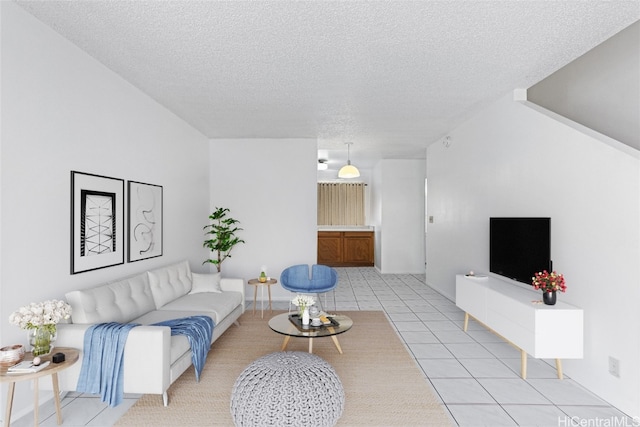 living room with a textured ceiling and light tile patterned floors