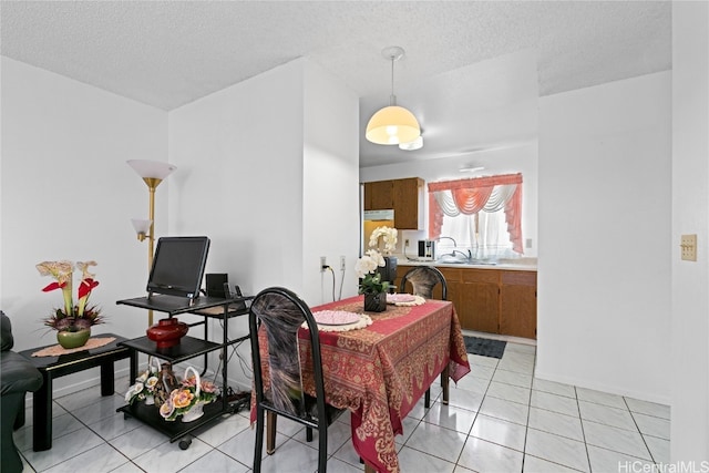 dining room featuring a textured ceiling and light tile patterned floors