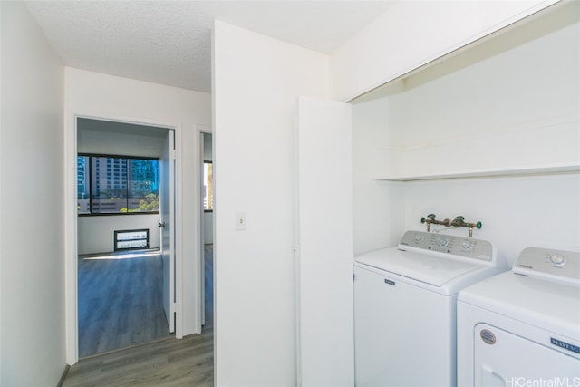 laundry area featuring a textured ceiling, hardwood / wood-style flooring, and washer and dryer