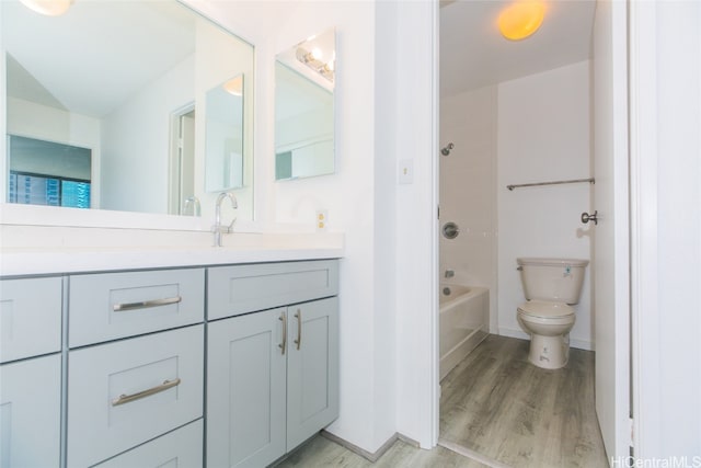 full bathroom featuring toilet, hardwood / wood-style floors, vanity, and bathing tub / shower combination