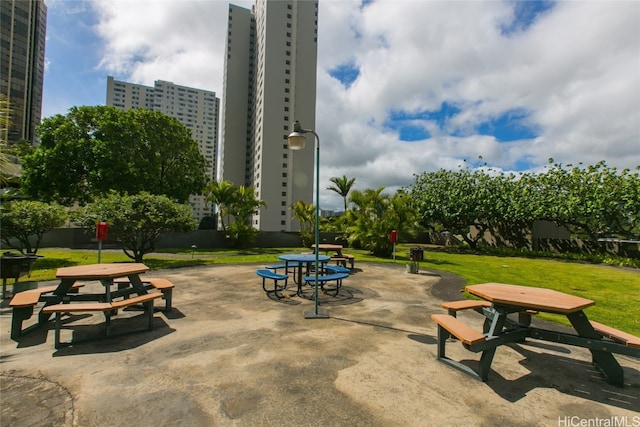 view of property's community featuring a patio and a lawn