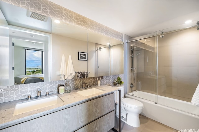 full bathroom featuring vanity, bath / shower combo with glass door, toilet, and backsplash