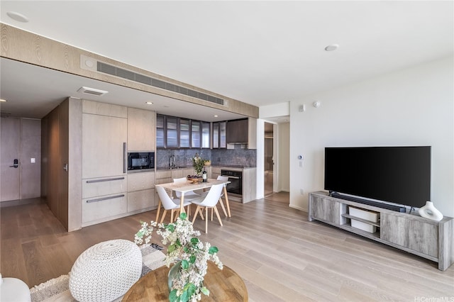 living area featuring light wood-type flooring and visible vents