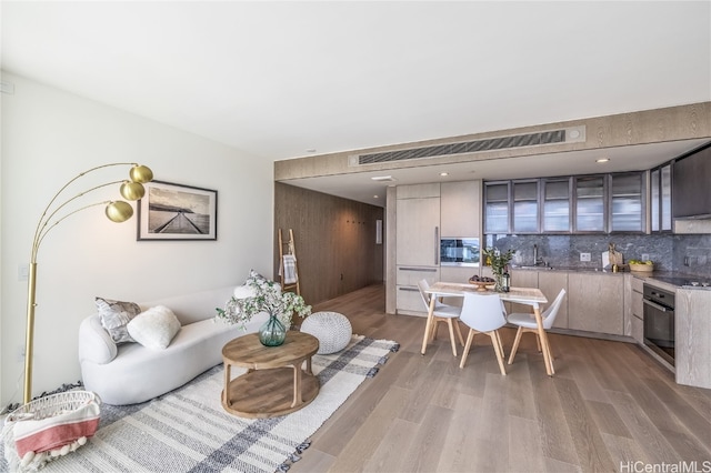 living room with sink and light hardwood / wood-style flooring