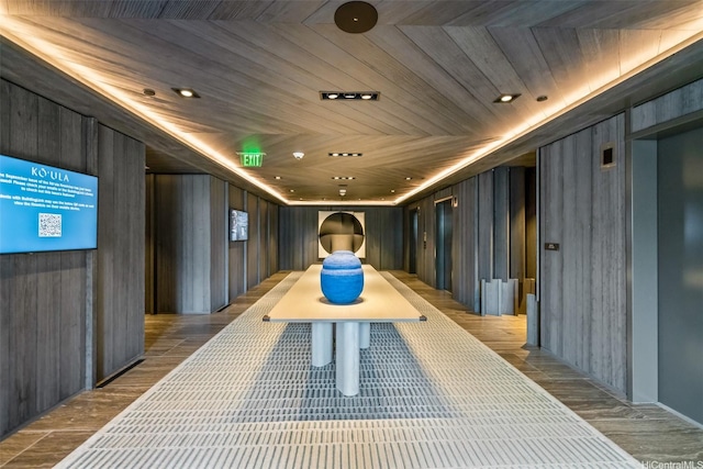 interior space with wooden ceiling, wood walls, and wood finished floors