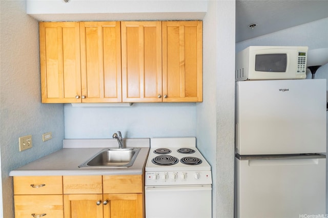 kitchen with white appliances, light brown cabinetry, a sink, and light countertops