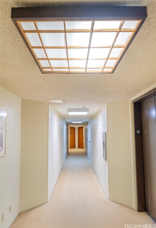 hallway featuring light colored carpet and elevator