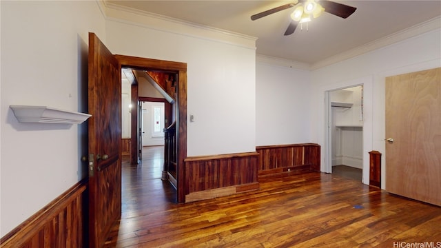 interior space featuring dark hardwood / wood-style floors, ceiling fan, crown molding, and wooden walls