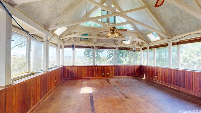 unfurnished sunroom with ceiling fan, lofted ceiling with skylight, and a wealth of natural light