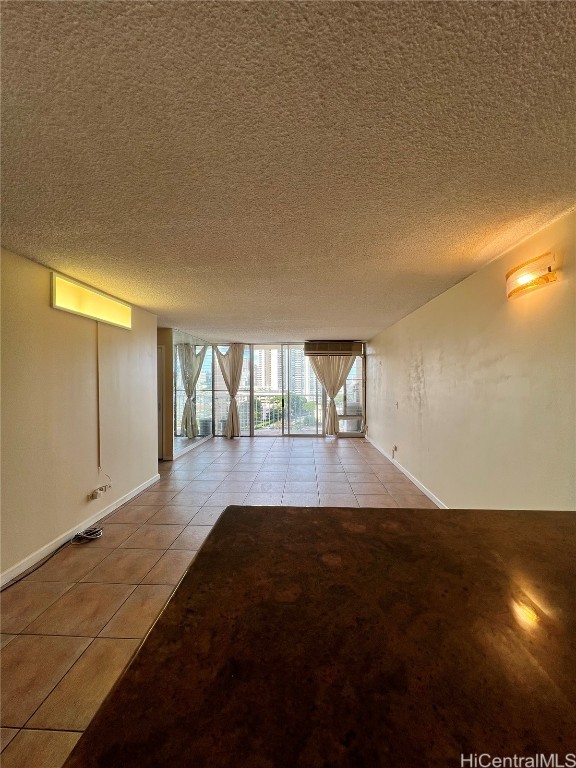 empty room featuring light tile patterned flooring and a textured ceiling