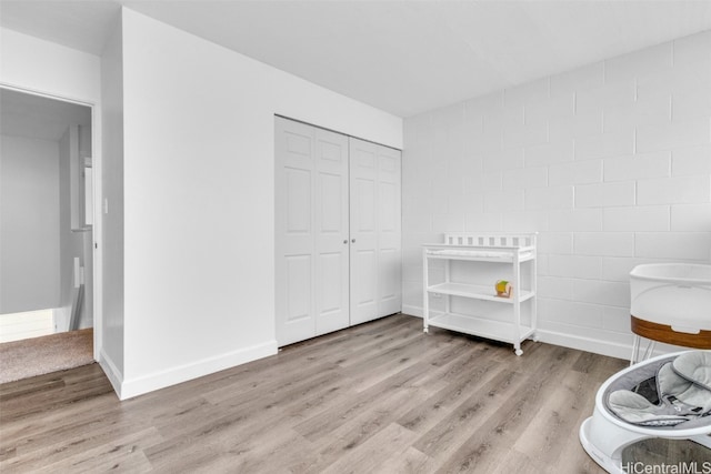 bedroom with light hardwood / wood-style floors and a closet