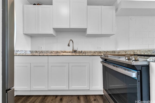 kitchen with appliances with stainless steel finishes, white cabinetry, sink, and dark hardwood / wood-style flooring