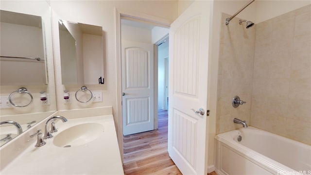 bathroom with tiled shower / bath, vanity, and hardwood / wood-style flooring