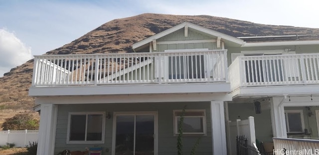 rear view of property with a balcony and a mountain view