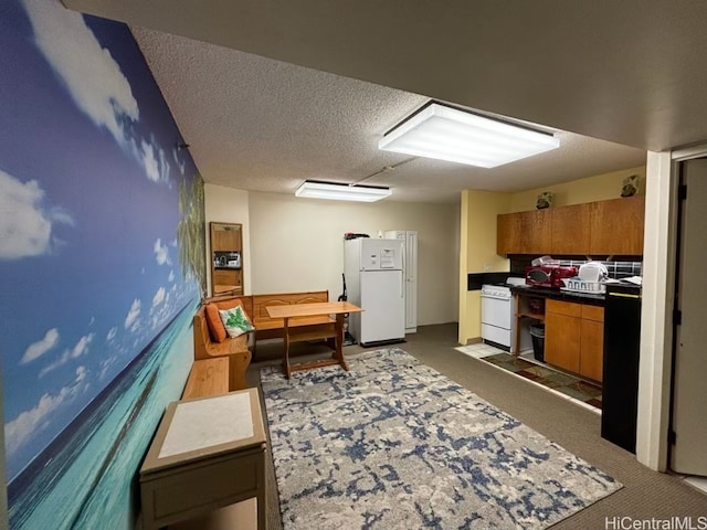 kitchen with a textured ceiling, white appliances, and dark colored carpet