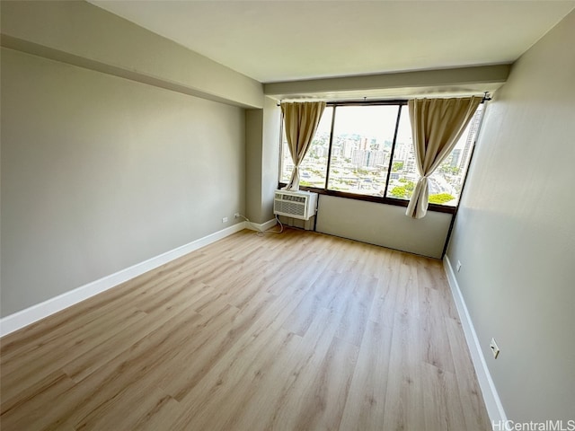 unfurnished room with light hardwood / wood-style floors and cooling unit