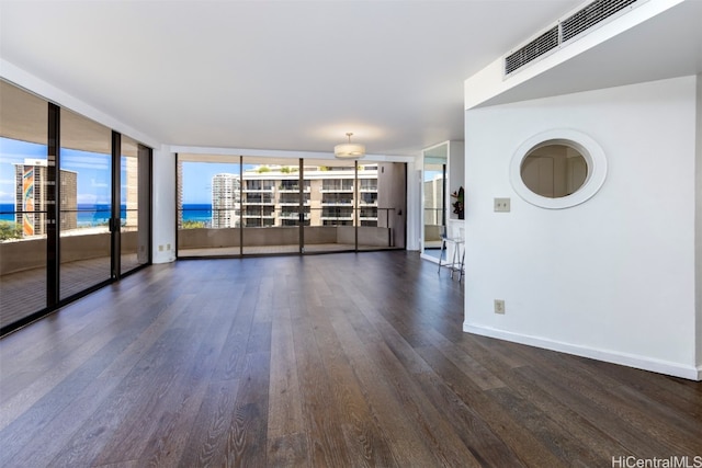 unfurnished room featuring a wall of windows, a water view, and dark hardwood / wood-style flooring